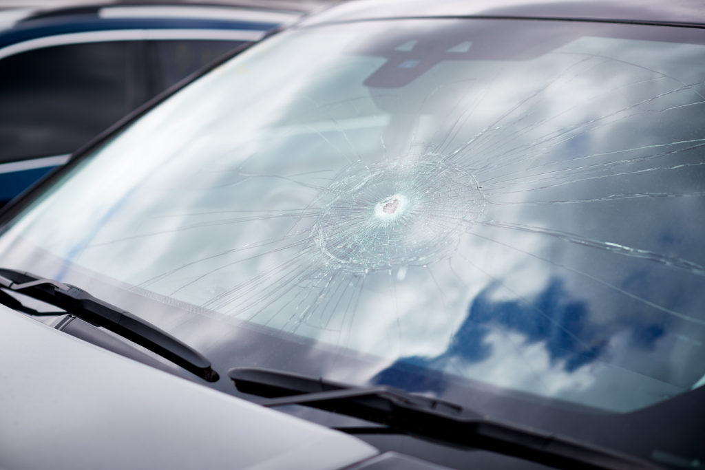 detail of damage to windscreen of car shattered by vandalism
